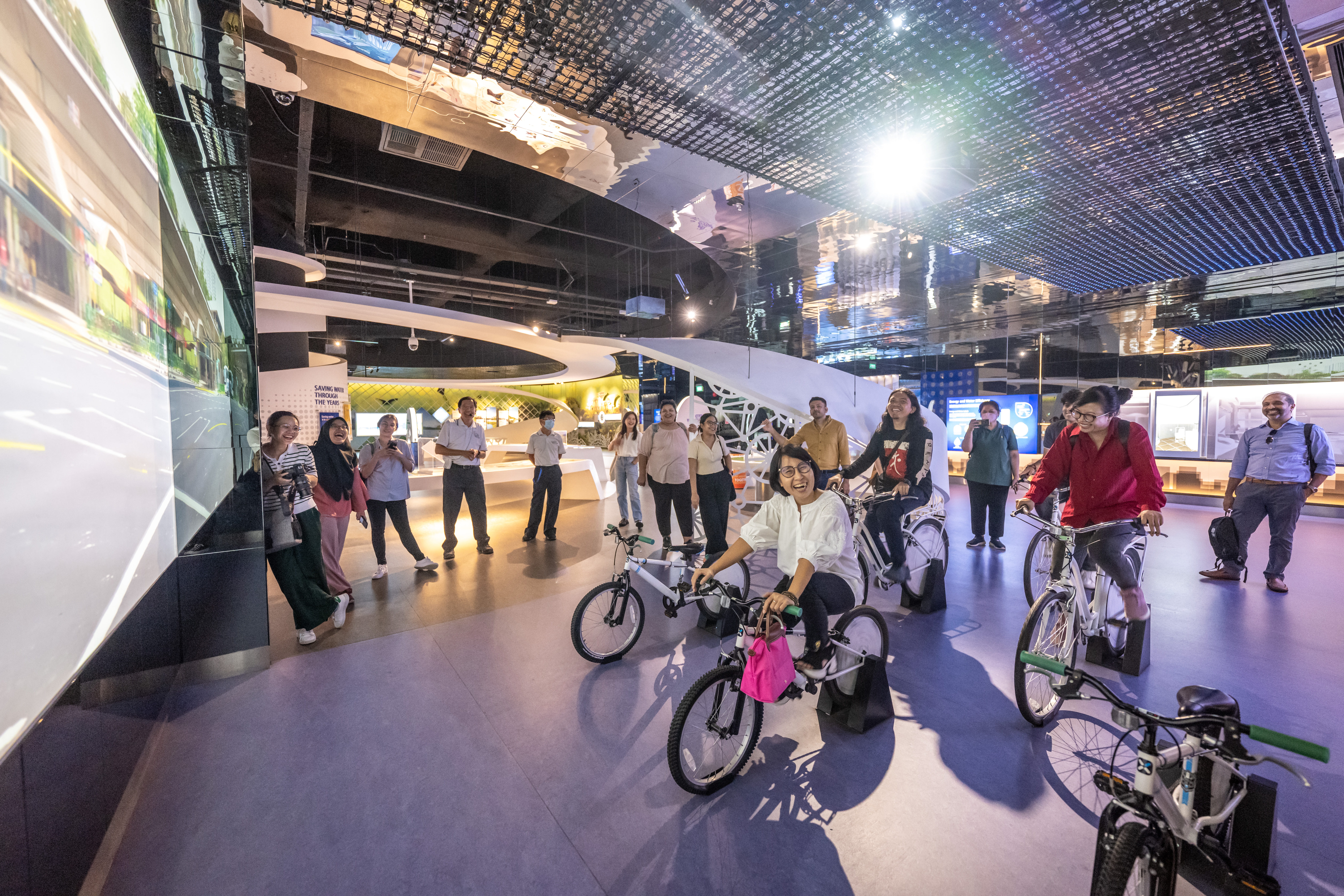 Journalists learning about Singapore's Park Connector Network (PCN) through a cycling simulation.